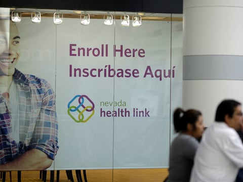 This Nov. 13, 2014 file photo people stand near an insurance store for Nevada Health Link at the Boulevard Mall in Las Vegas.